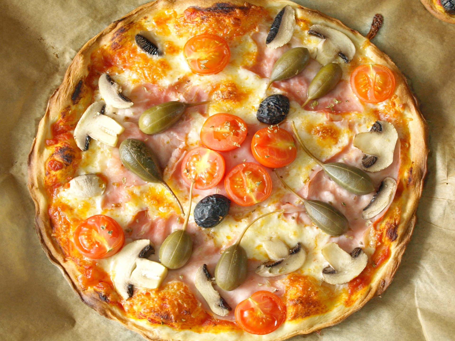 Pizza mit Schinken, Pilzen und Kapernpfeln
