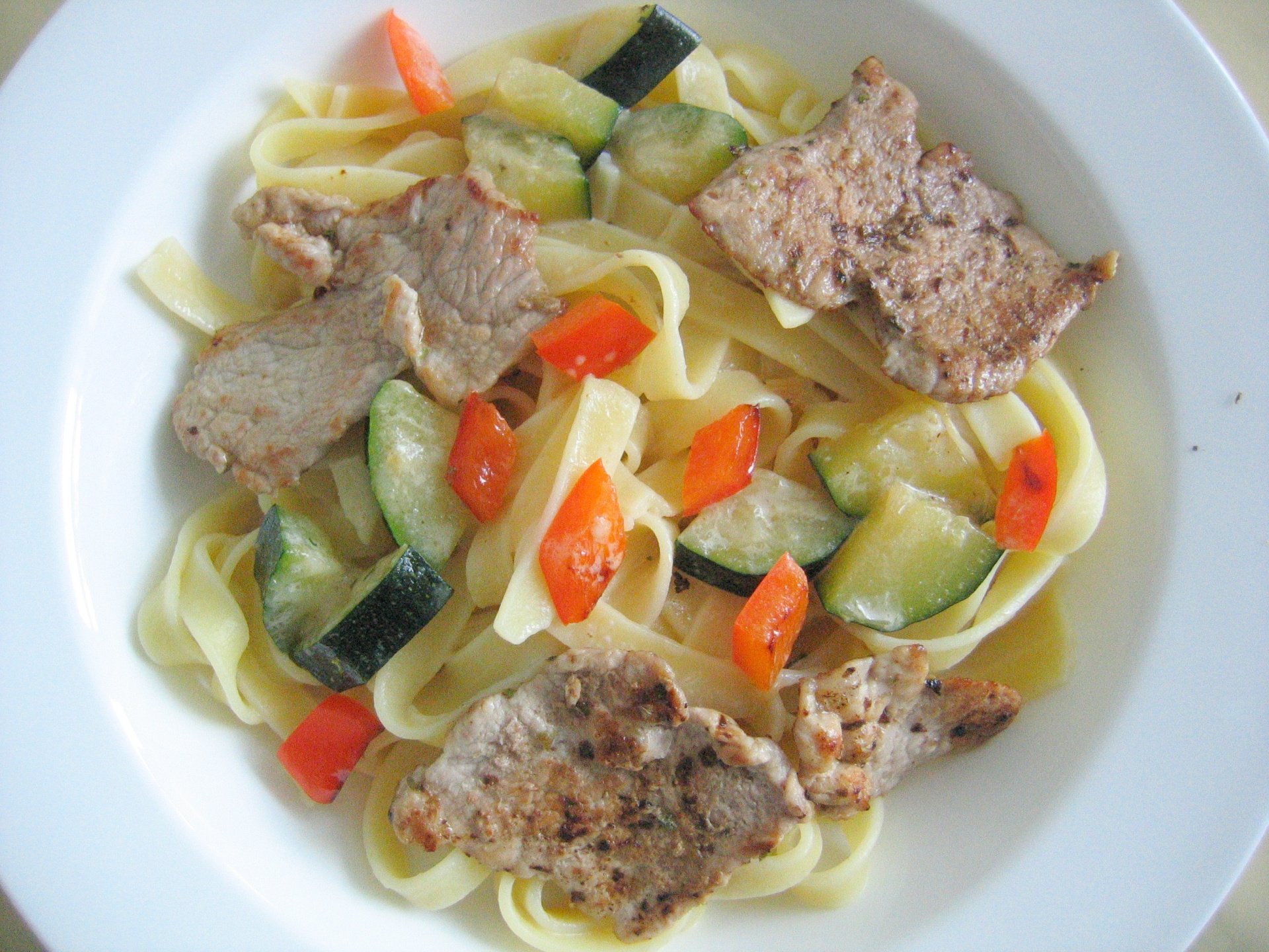 Schweinefiletscheiben auf Bandnudeln mit
              Zucchini