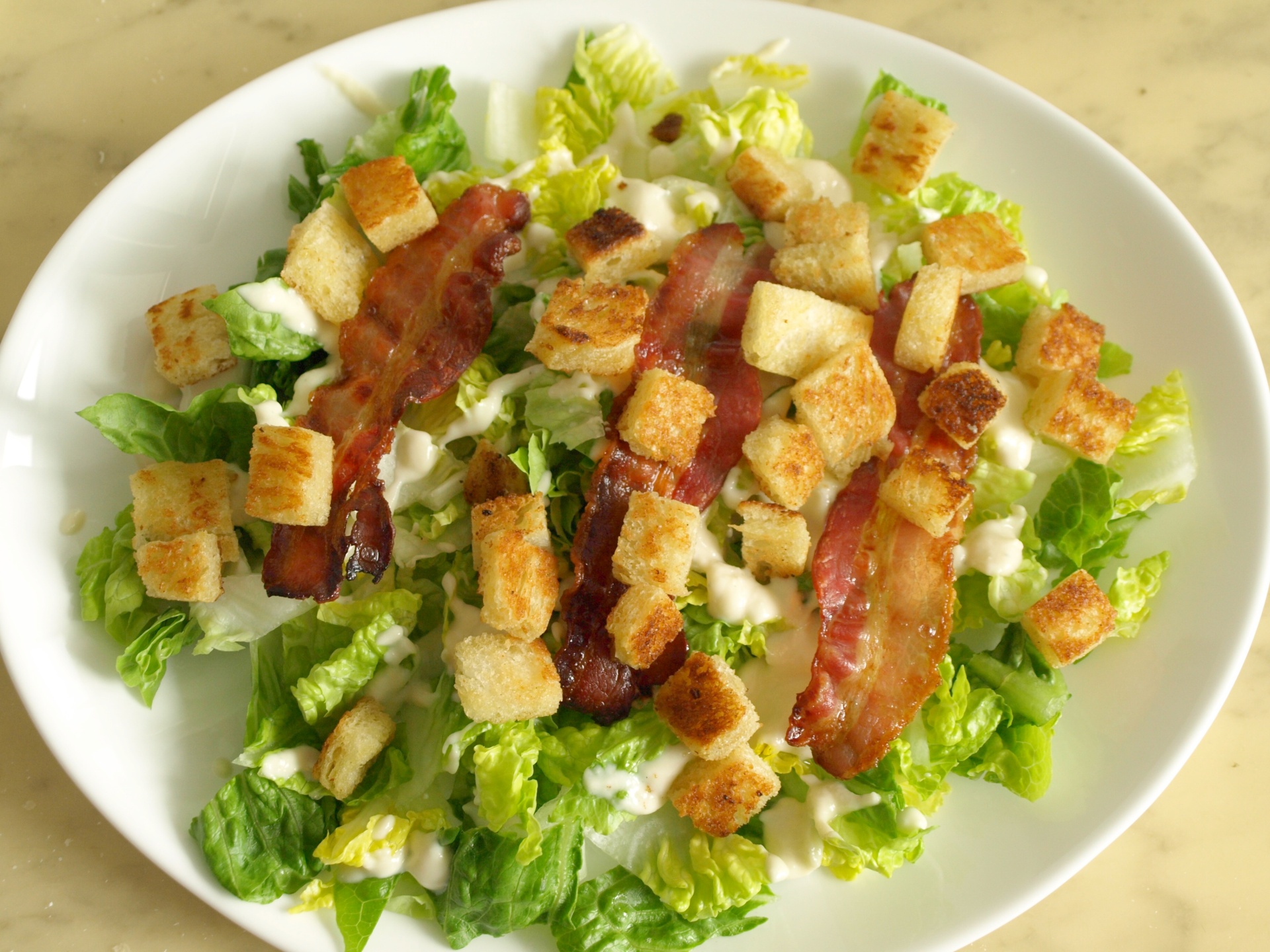 Romanasalat mit Blue-Cheese-Dressing,
              Speckscheiben, Crotons