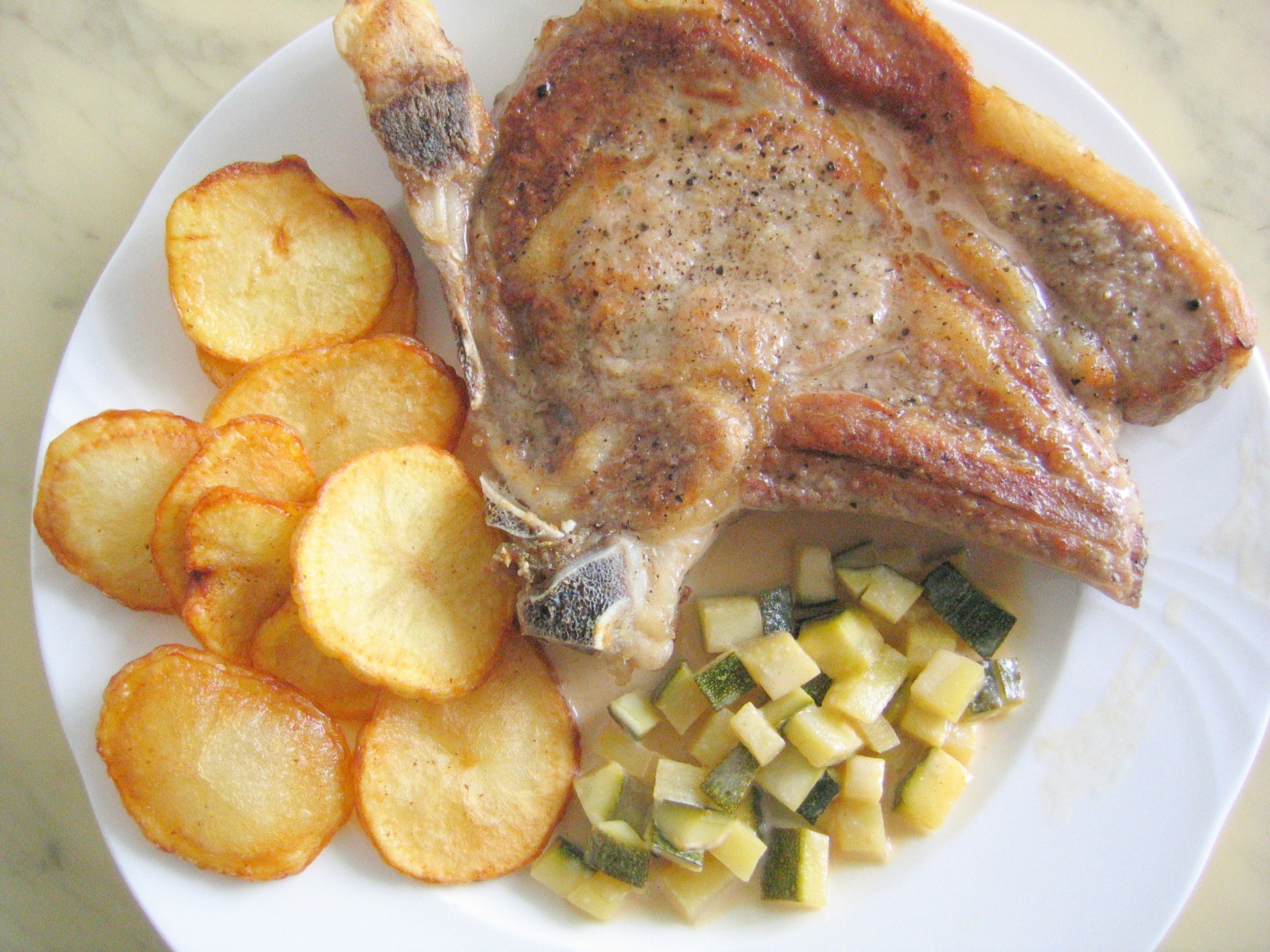Kalbskotelett mit Zucchinigemse und
              frittierten Kartoffelscheiben