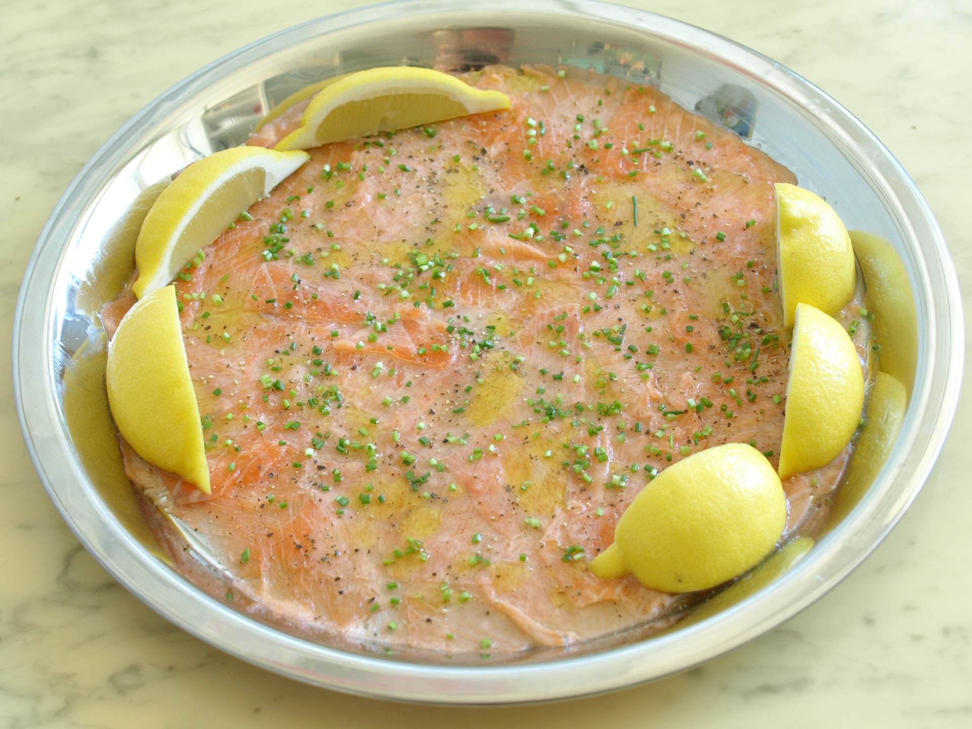 Lachscarpaccio mit Zitronenpfeffer,
              Schnittlauch und Olivenl