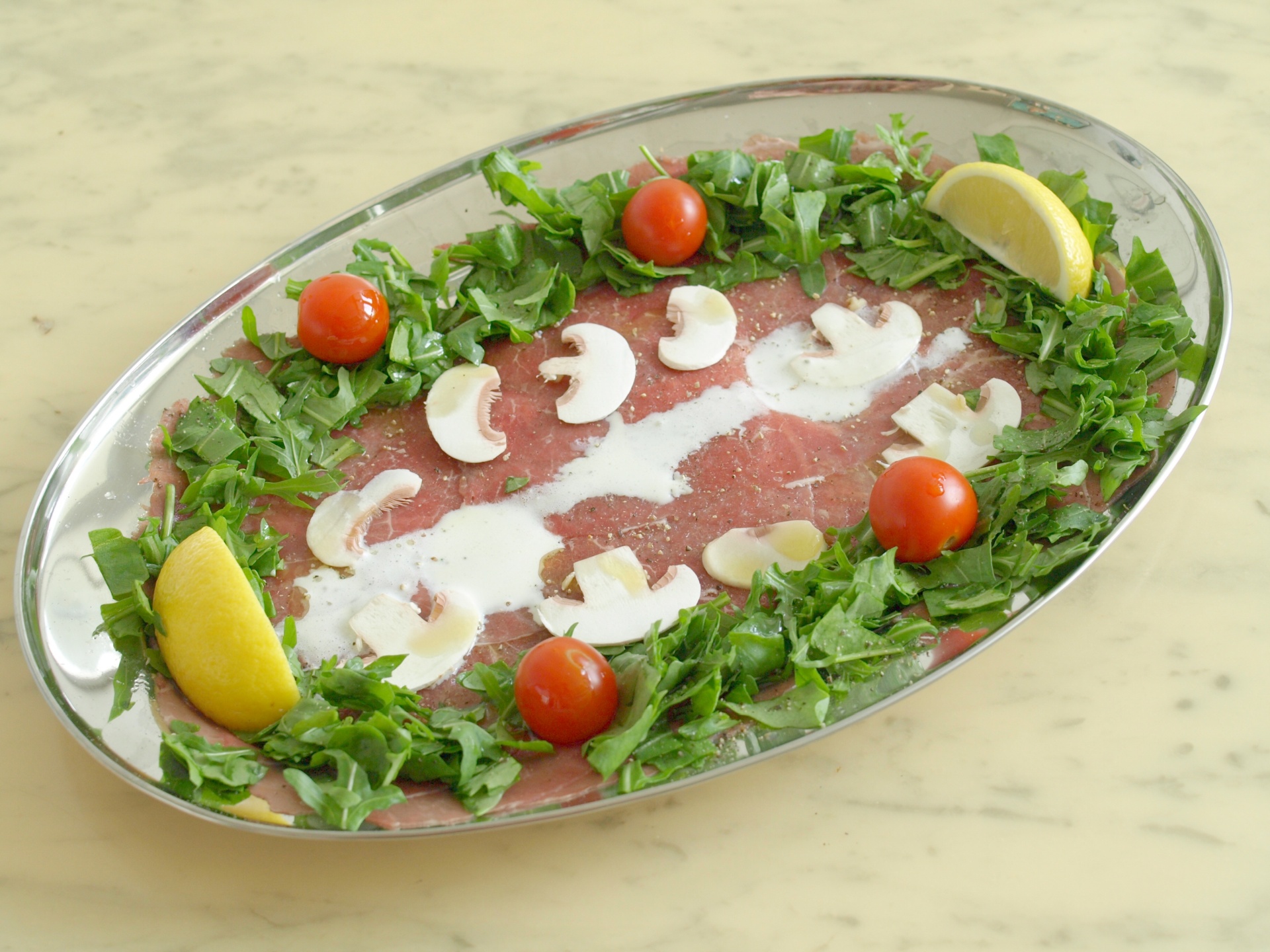 Carpaccio vom Rinderfilet mit Zitronenpfeffer
              und Rucola