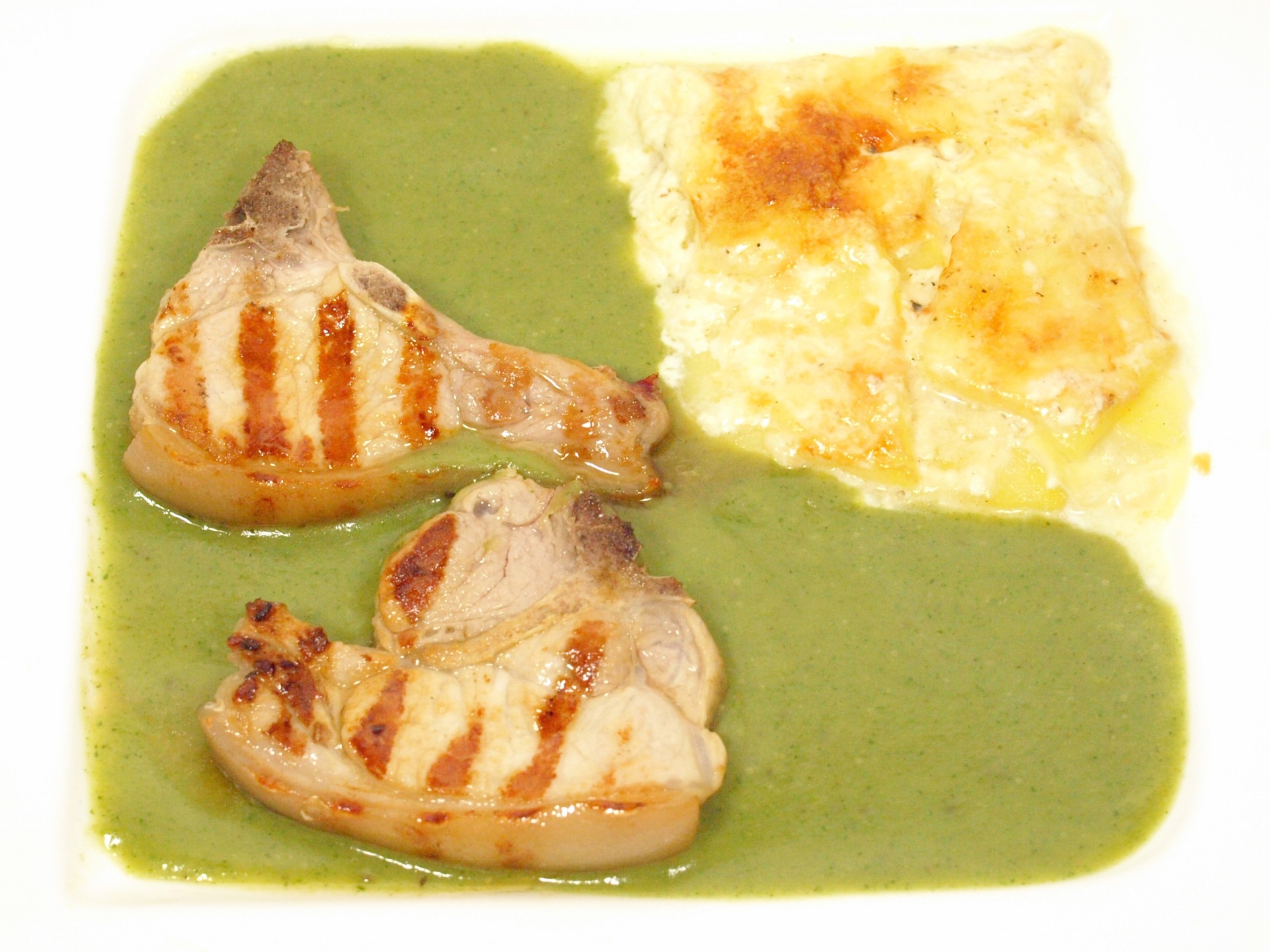 Spanferkelkoteletts mit Broccolisauce und
              Kartoffelgratin