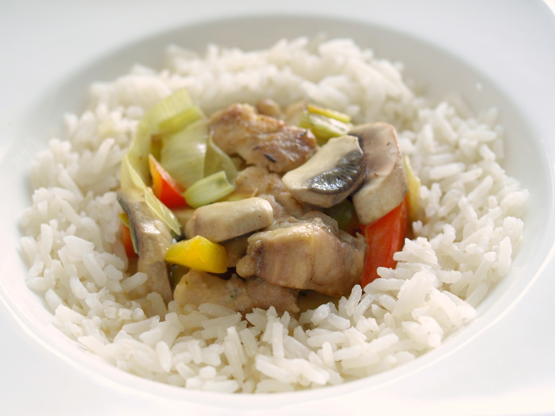 Ausgelste Hhnchenoberschenkel mit Paprika
              und Pilzen im Reisrand