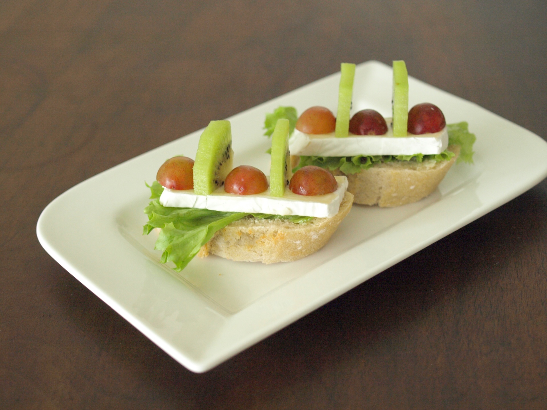Canaps mit Weichkse, Trauben und Kiwi