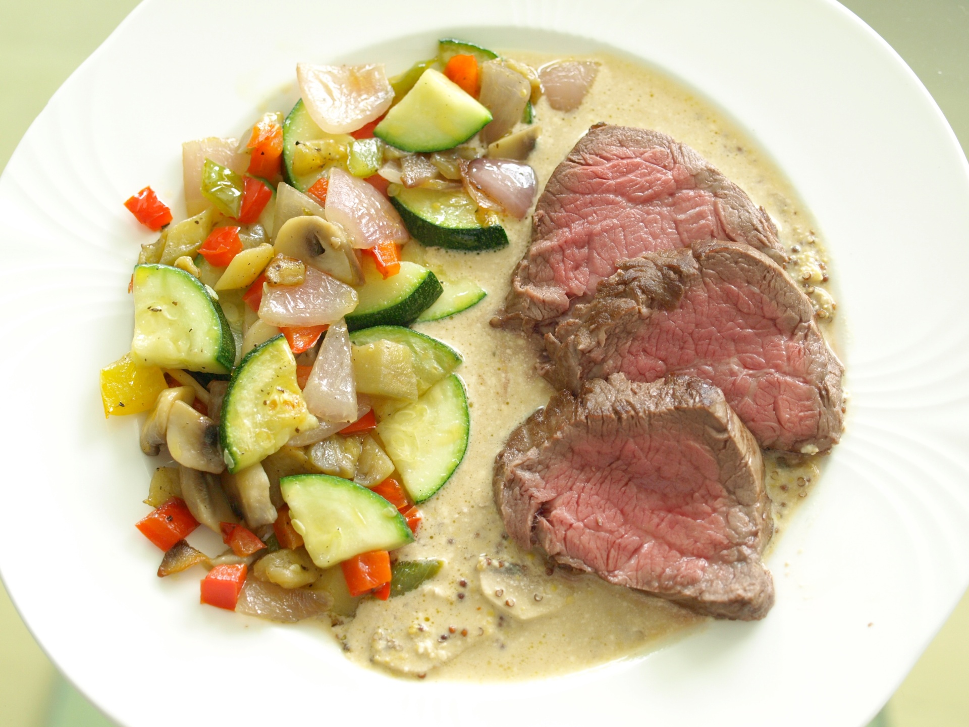 Rosa gebratenes Rinderfilet mit mediterranem
              Gemse