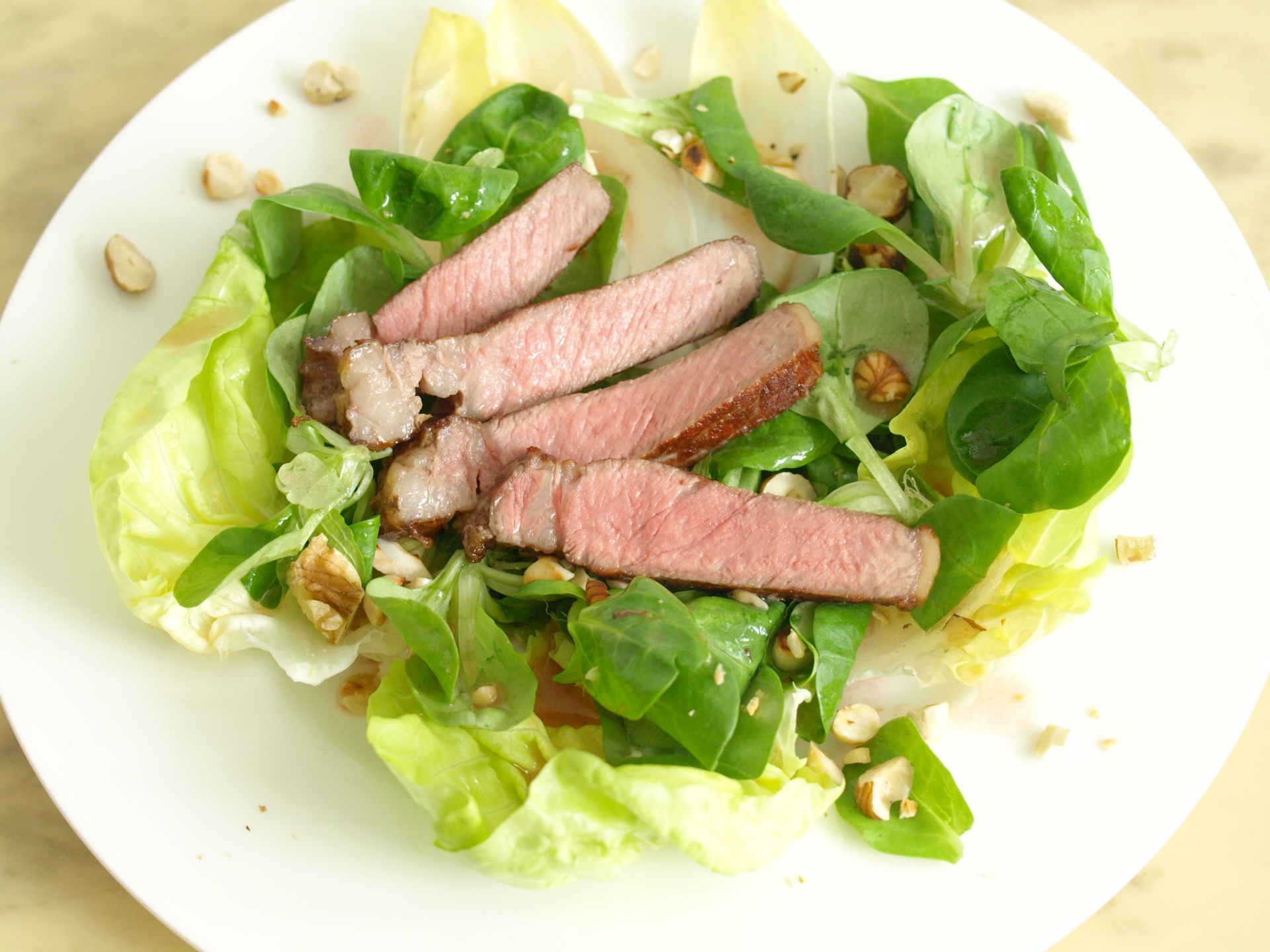 Rumpsteakstreifen auf Blattsalaten mit
              Nuss-Vinaigrette