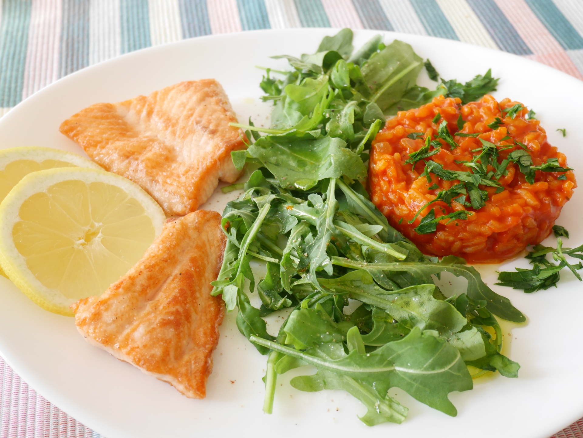 Lachs, kross gebraten, mit Tomatenrisotto und
              Rucola